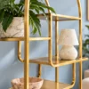 Aurelia Arc arched cosmetic display rack with gold frame and asymmetrical shelves