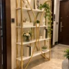 Aurevia curved frame cosmetic display rack with gold frame and white shelves