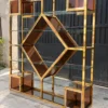 Aurex Geo geometric cosmetic display rack with gold frame and amber accents