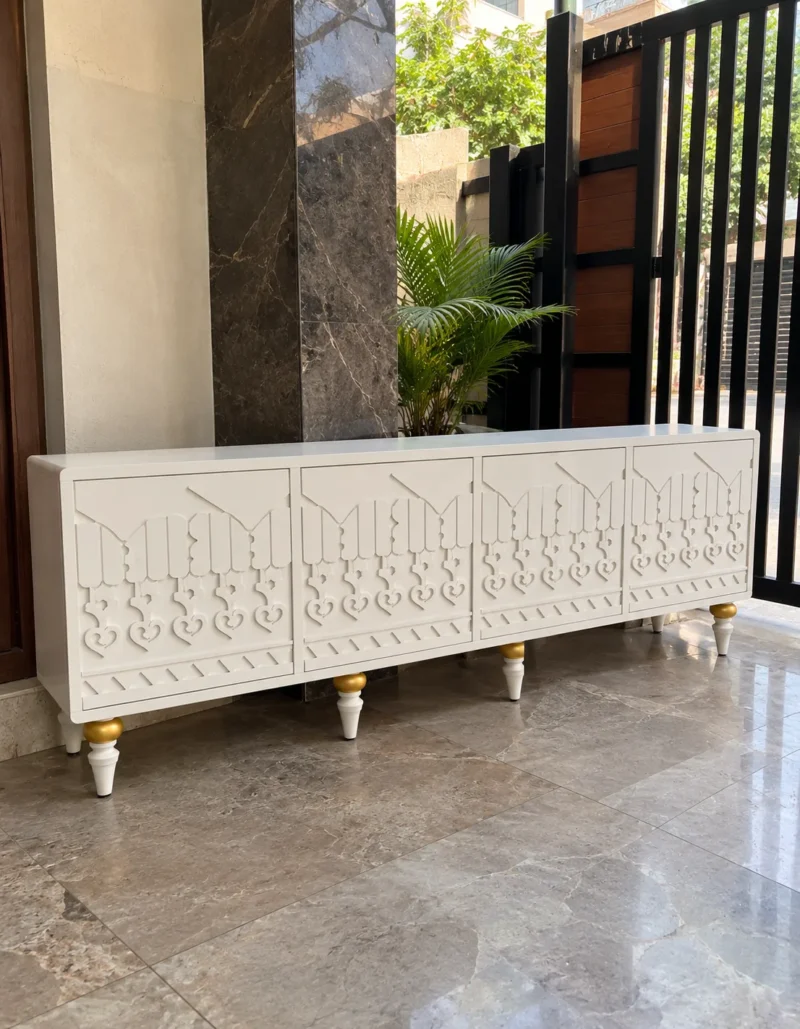 Liora Carve white TV unit with four patterned doors and gold-tone leg accents