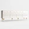 Liora Carve white TV unit with four patterned doors and gold-tone leg accents