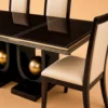 Orion black dining table with three gold sphere supports and four cream chairs