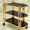 Orlena Luxe rounded edge serving trolley with gold frame and black serving surfaces