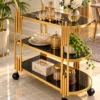 Orlena Luxe rounded edge serving trolley with gold frame and black serving surfaces