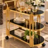 Orlena Luxe rounded edge serving trolley with gold frame and black serving surfaces