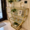 Velora hourglass cosmetic display rack with curved gold frame and three open shelves
