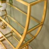 Velora hourglass cosmetic display rack with curved gold frame and three open shelves