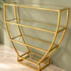 Velora hourglass cosmetic display rack with curved gold frame and three open shelves