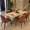 Veyra Cross marble dining table with dark sculptural base and four upholstered chairs
