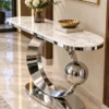 Designer marble top console table with chrom circular frame displayed against a light blue wall.