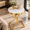 Designer round marble side table with gold metal base near a living room window