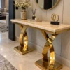 Gold marble console table with twin curved X pedestals beneath round wall mirror