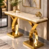 Double X base marble console table with polished gold supports in luxury foyer