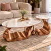 Luxury marble centre table set of 2 with copper curved bases styled on a rug in front of a beige living room sofa.