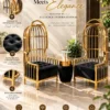 Aurelio Luxe gold stainless steel accent chairs with tall birdcage backrests, black tufted fabric seats and coordinating side table.
