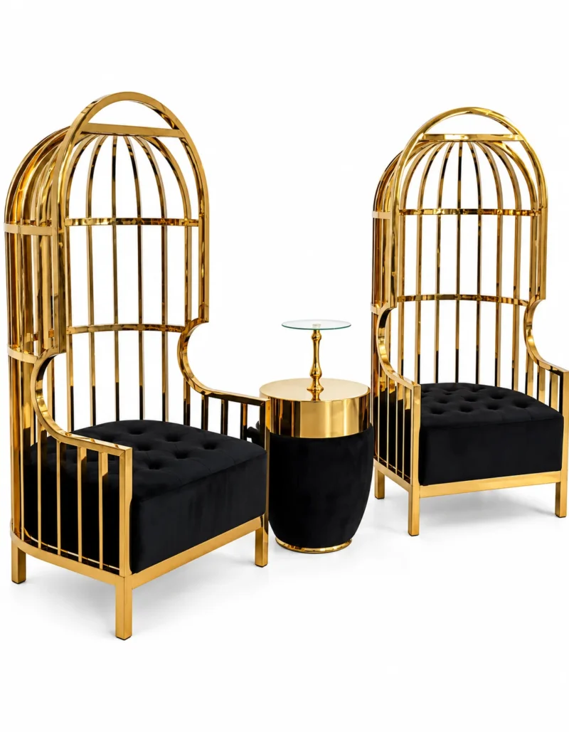 Two Aurelio Luxe gold stainless steel birdcage accent chairs with black tufted fabric seats and coordinating table on white background.