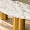Close-up of white marble centre table showing grey and gold veining, polished oval edge and brushed gold stainless steel cylindrical pedestal.