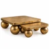 Aurevia Luxe gold sphere nesting centre table set of two with rounded square marble tops and antique-gold spherical stainless steel supports.