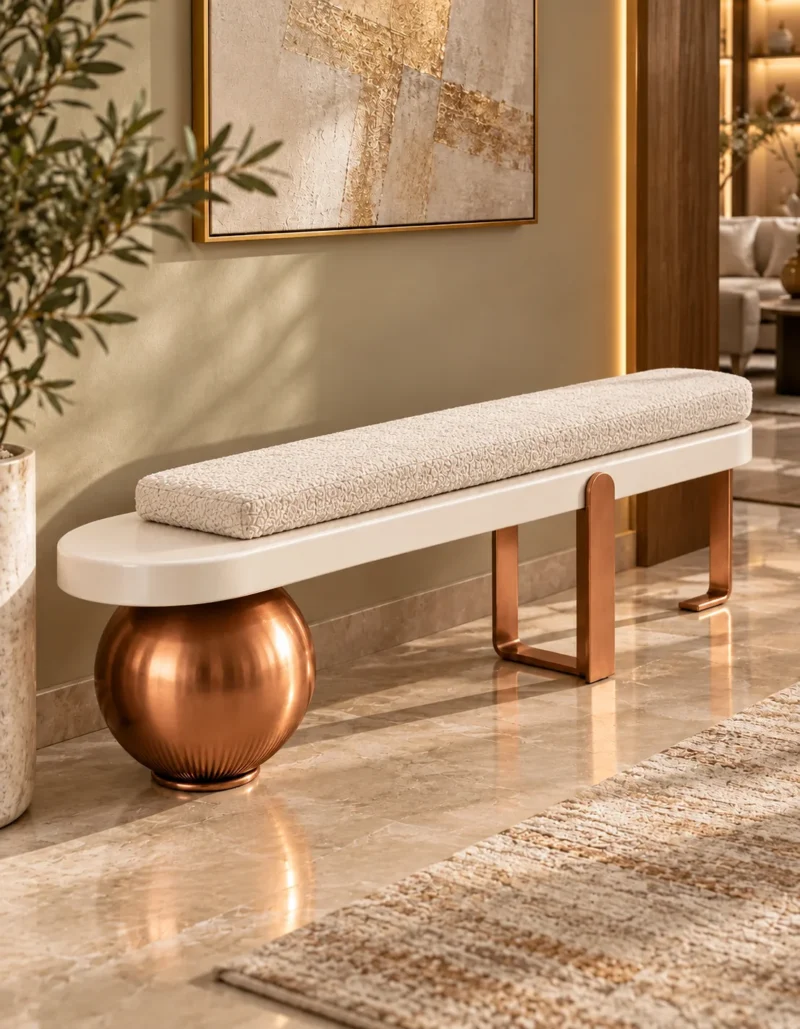 Modern ivory bouclé bench with elongated upholstered cushion, cream platform and copper sculptural supports in a luxury living room.