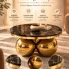 Aurevian round black marble centre table with gold stainless steel sphere base and premium marble surface.