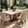 Luxury rectangular marble dining table with rose-gold loop pedestal and six cream chairs beside a garden-facing glass doorway.