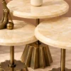 Close-up of cream marble tabletops and gold fluted stainless steel pedestal bases