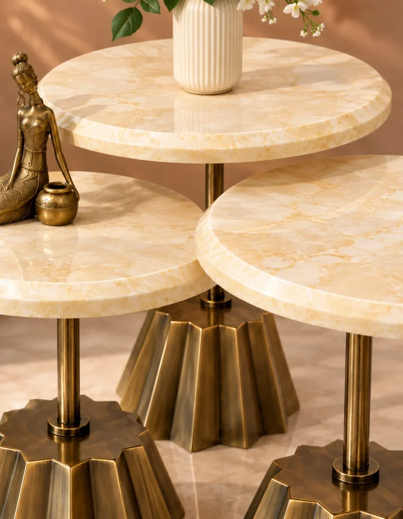 Close-up of cream marble tabletops and gold fluted stainless steel pedestal bases
