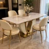 Designer marble dining table with cream chairs and gold base