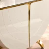 Close up of white curved console cabinet with gold stainless steel trim