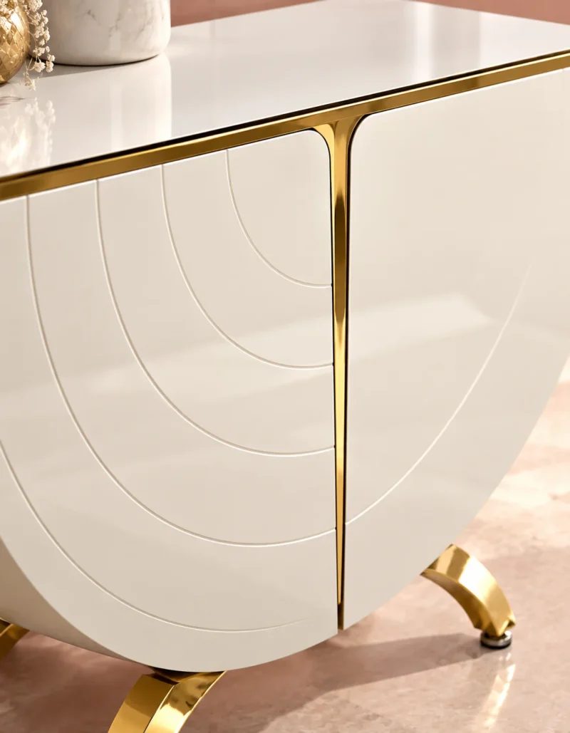 Close up of white curved console cabinet with gold stainless steel trim
