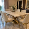 Luxury marble dining table set with cream upholstered chairs and gold curved X base