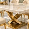 Close-up of gold veined marble tabletop and curved X shaped stainless steel dining table base