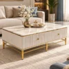 Luxury white marble coffee table with fluted storage panels and gold PVD stainless steel legs in front of a beige sofa.