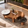 High-angle view of freeform Antique copper centre table featuring a raised white marble disc and black marble side platform on cylindrical legs.