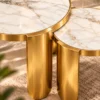Close-up of white marble nesting centre tables showing gold veining, metallic tabletop rims and curved stainless steel legs.