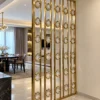 Gold stainless steel premix glas partition separating modern living and dining spaces