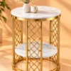 Round marble side table with gold steel lattice panels against a warm orange background