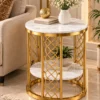 Gold marble accent table beside a beige sofa with a plant on its lower shelf