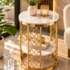 Gold lattice side table near a window with a flower vase and candle on the marble top