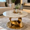 Round marble centre table with sculptural gold stainless steel base in living room