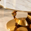 Close view of marble top and gold stainless steel crescent table base