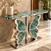 Designer green marble console table with butterfly-shaped stainless steel pedestal in an elegant marble-floored foyer.