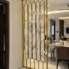 Vertical marble-design gold stainless steel room divider near dining room entrance