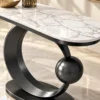 Close-up of polished white marble console tabletop with grey veining and black stainless steel sculptural frame.