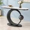 Designer marble top console table with matte black circular frame displayed against a light blue wall.