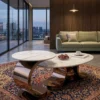 Sculptural marble centre table set of two with white veined tops and dark metallic loop bases in a modern living room