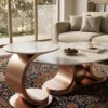 Rose gold brushed metal curved coffee table with Calacatta marble top placed on traditional oriental carpet
