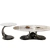 Matte black metallic curved base oval white marble coffee table set on seamless white studio background