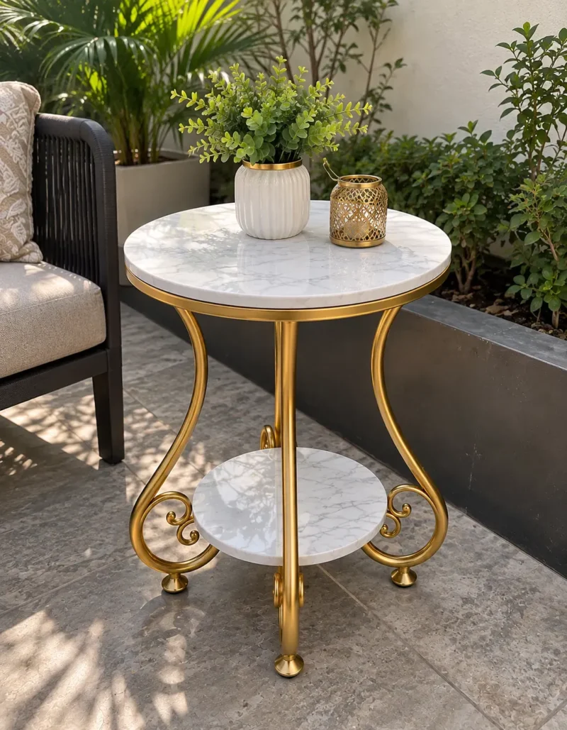 Gold marble side table with decorative curved legs and double-tier shelves displayed beside patio seating