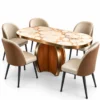 Orvella Luxe oval marble dining table set with white gold-veined marble top, sculptural pedestal and cream-and-caramel chairs on white background.